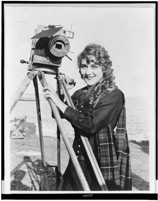Mary Pickford with motion picture camera on beach